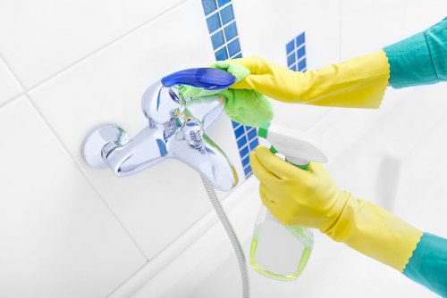 Staff member using protective gloves while handling cleaning products